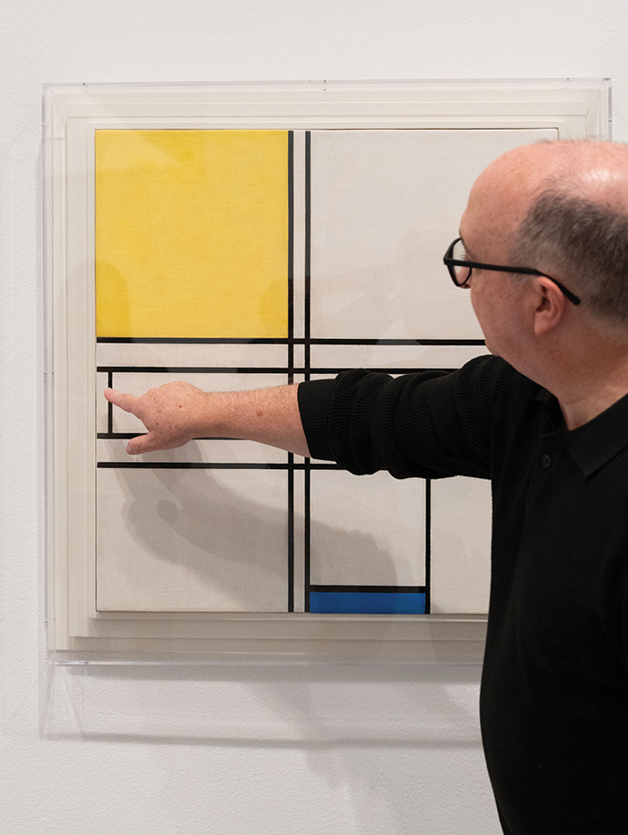 Scott Nolley points to a painting