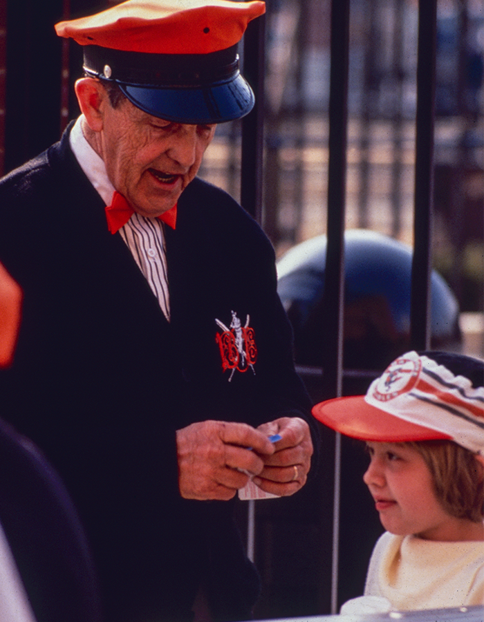 an usher welcomes a guest to Camden Yards