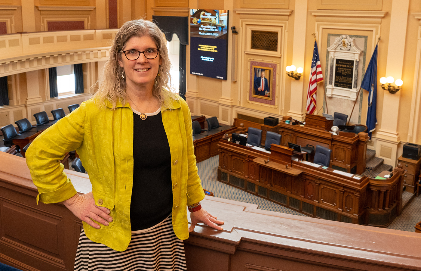 Tricia Vaughan stands along the second floor balcony overlooking the floor of the Virginia House of Delegates